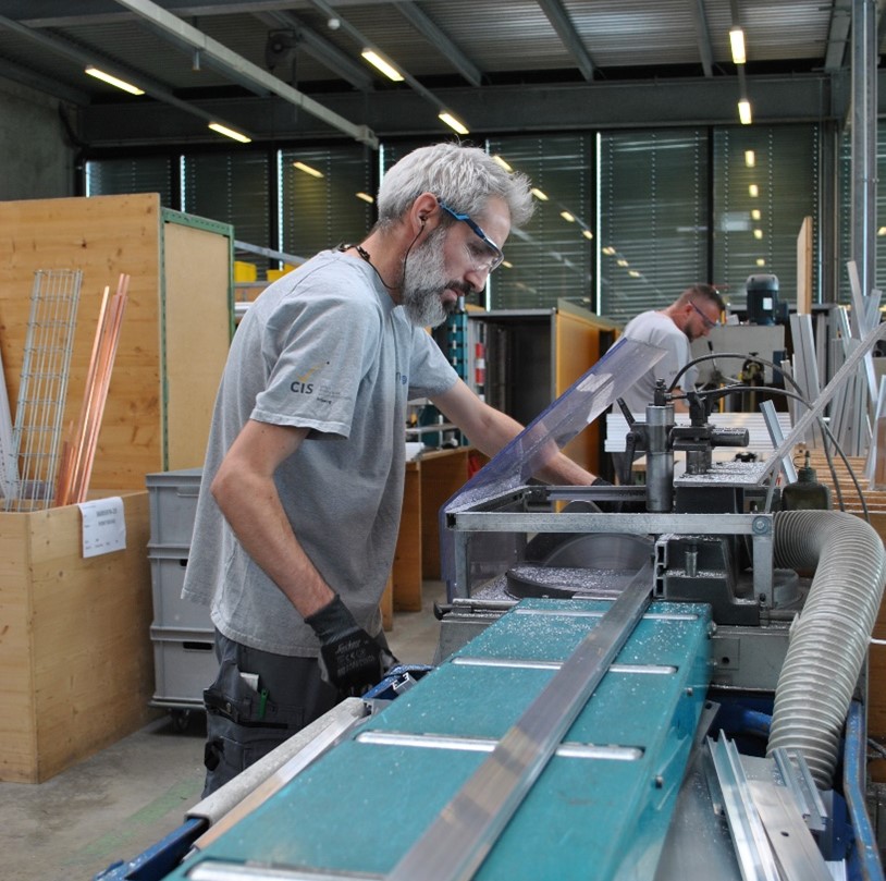 Collaborateur du CIS travaillant sur une machine dans les ateliers du Groupe E