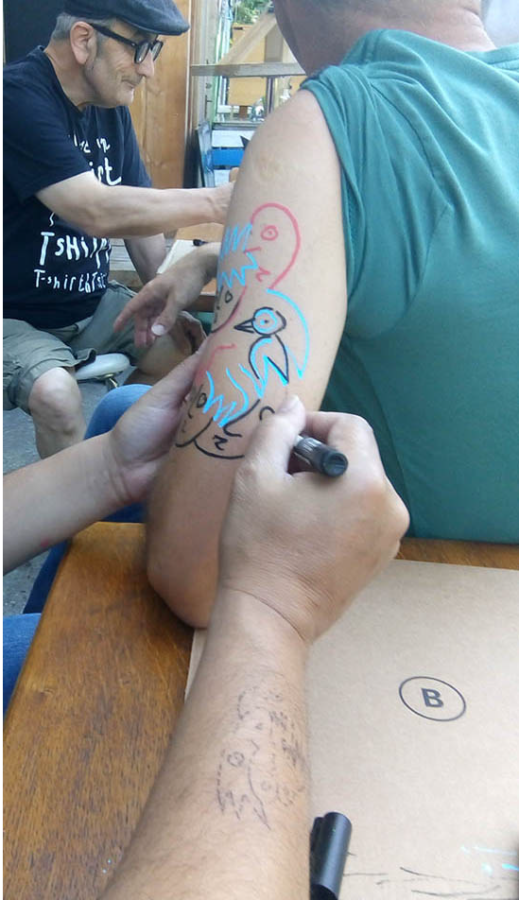 une personne qui fait un tatouage éphémère sur le bras