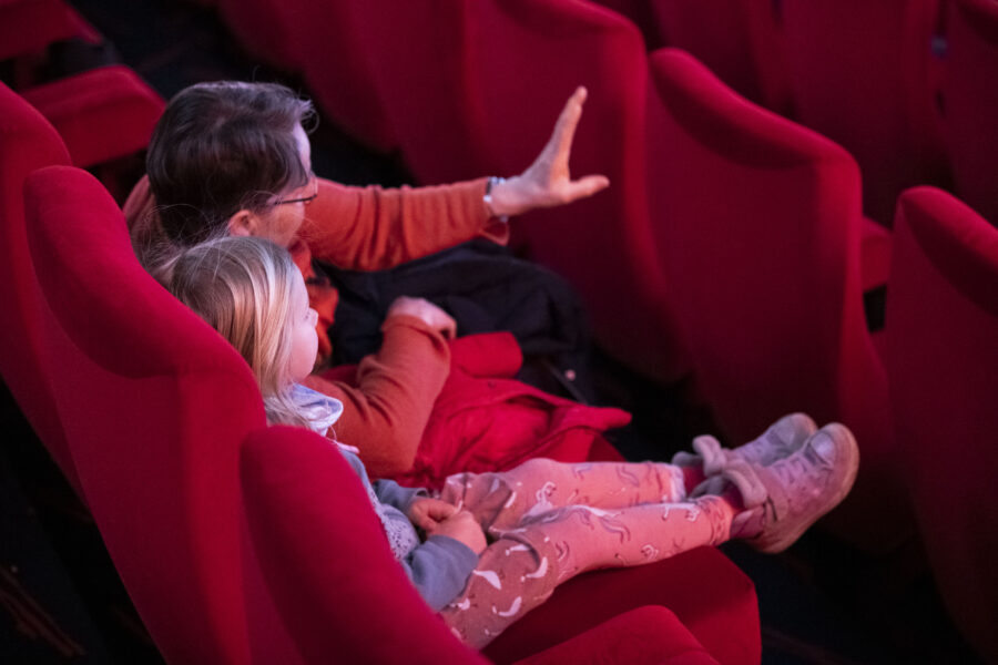 un adulte et un enfant assis dans une salle de cinéma