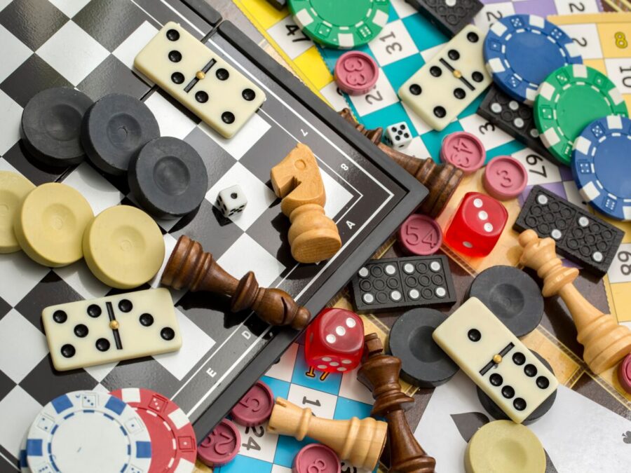 Un ensemble un peu désordonné de jeux, tels que des dés à lancer, des pièces d'un jeu d'échec, de dominos ou encore de jetons de poker.