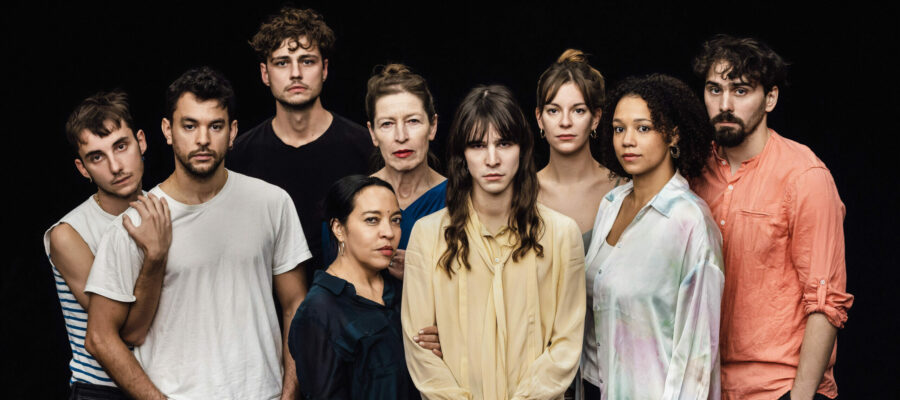 C’est une photo avec 9 personnes qui regardent dans notre direction. Il y a des hommes et des femmes. Toutes les personnes nous regardent avec un air sérieux.